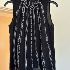 Sleeveless high neck black and white top.